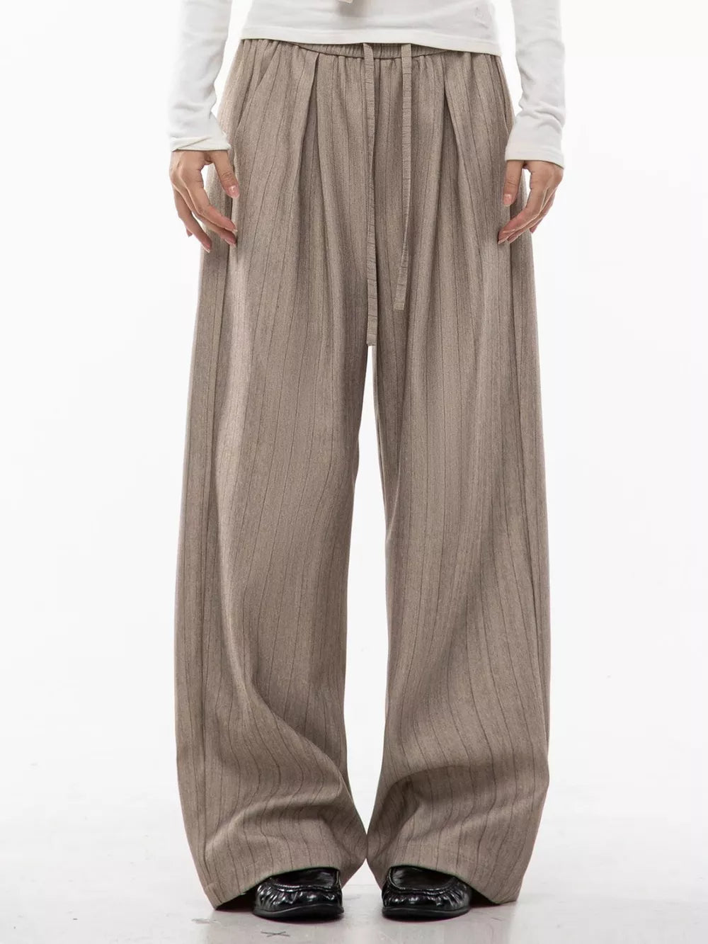 Khaki wide-leg pleated trousers with pinstripes and drawstring waist.