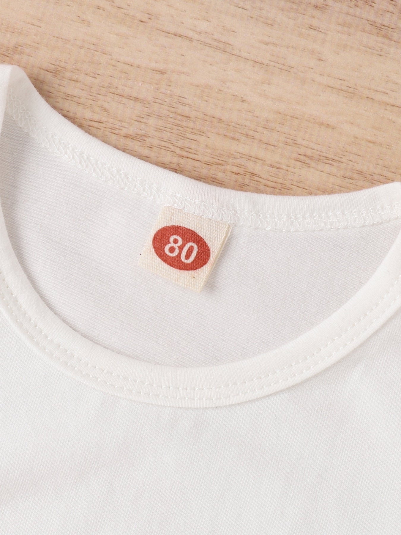White baby t-shirt with size 80 tag