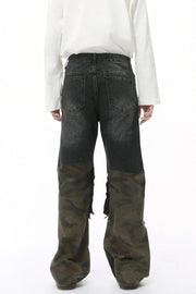 Distressed wide-leg jeans with dark denim and camouflage panels, featuring raw hems.