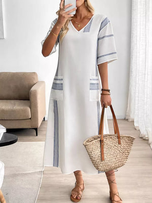 White maxi dress with blue stripes, V-neck, short sleeves, and pockets.