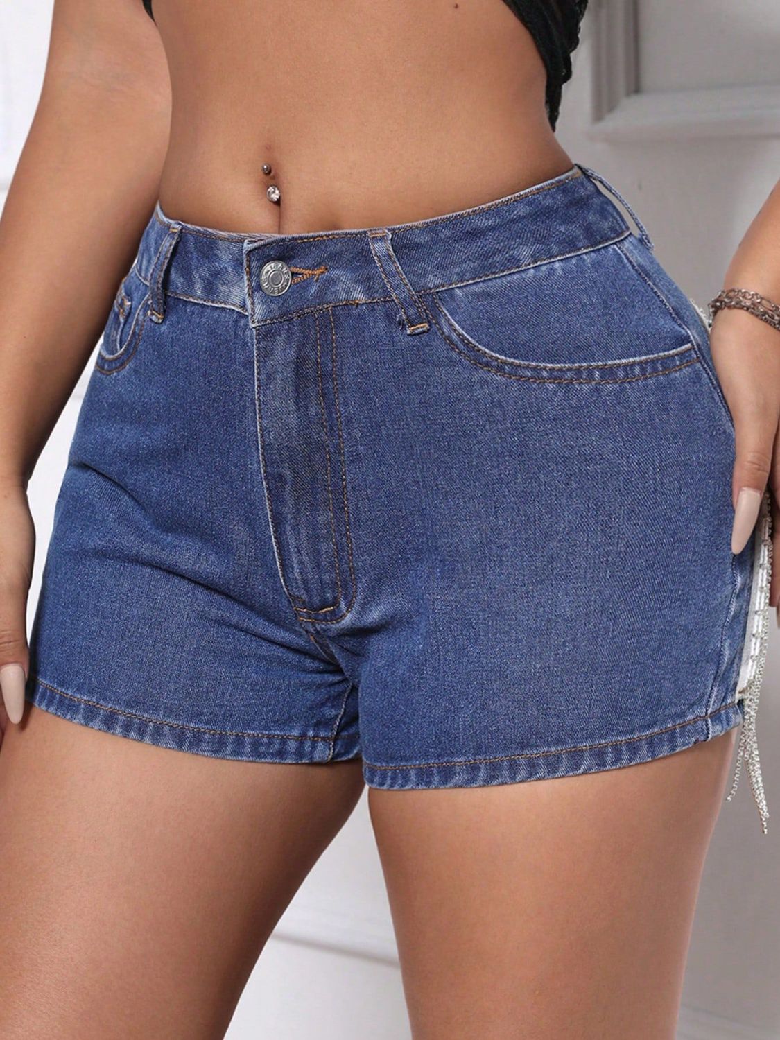Medium wash denim shorts with crystal fringe detail on the side.