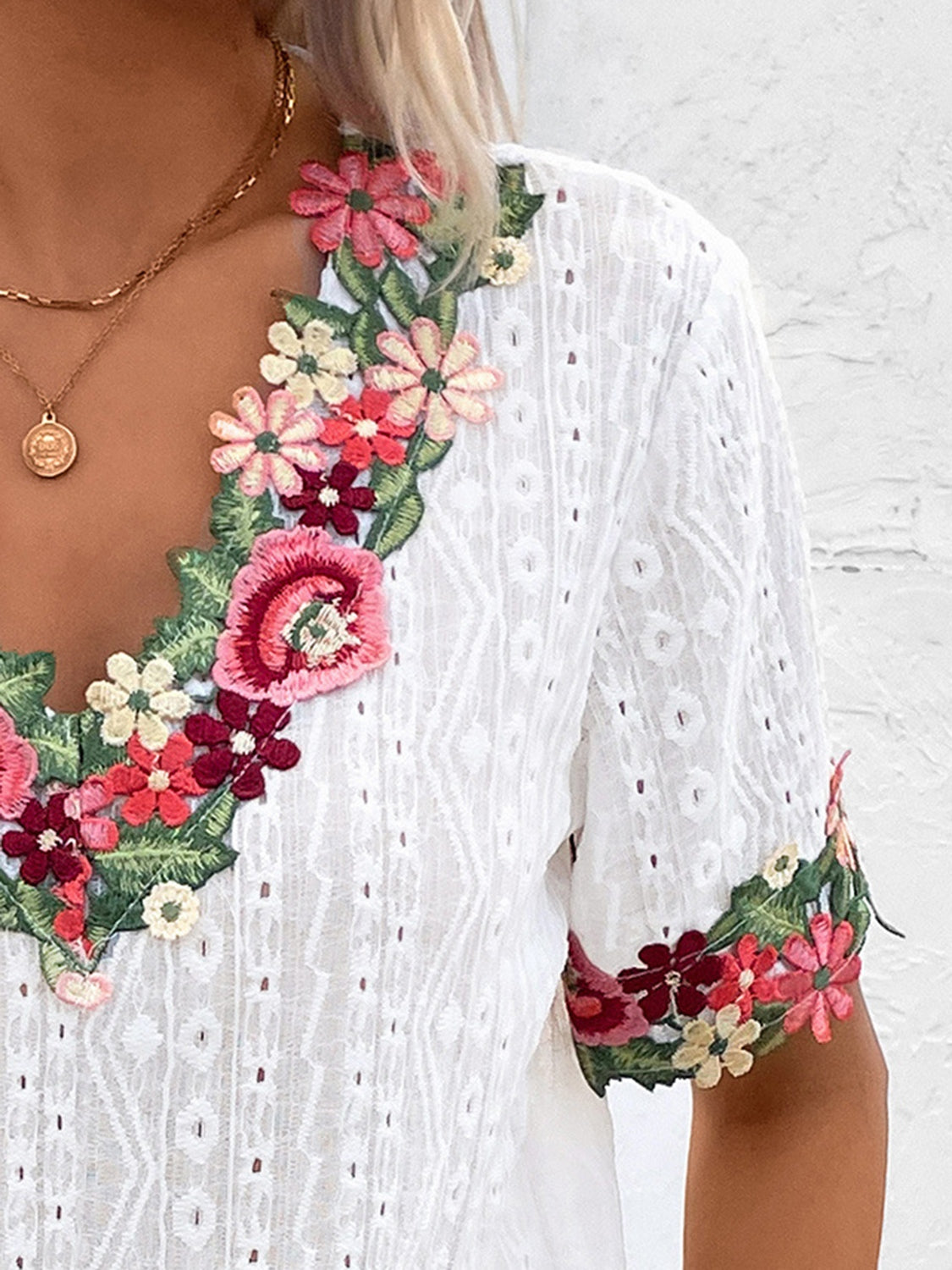 White eyelet peasant blouse with embroidered floral V-neck and sleeves