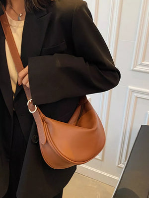 Brown minimalist crescent crossbody bag with adjustable strap.