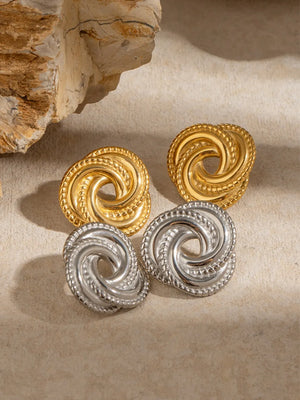 Golden swirl knot stud earrings in gold and silver finishes with textured edges.