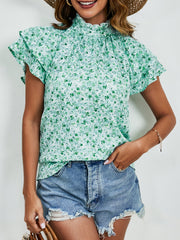 Light green floral blouse with ruffled neckline and flutter sleeves.