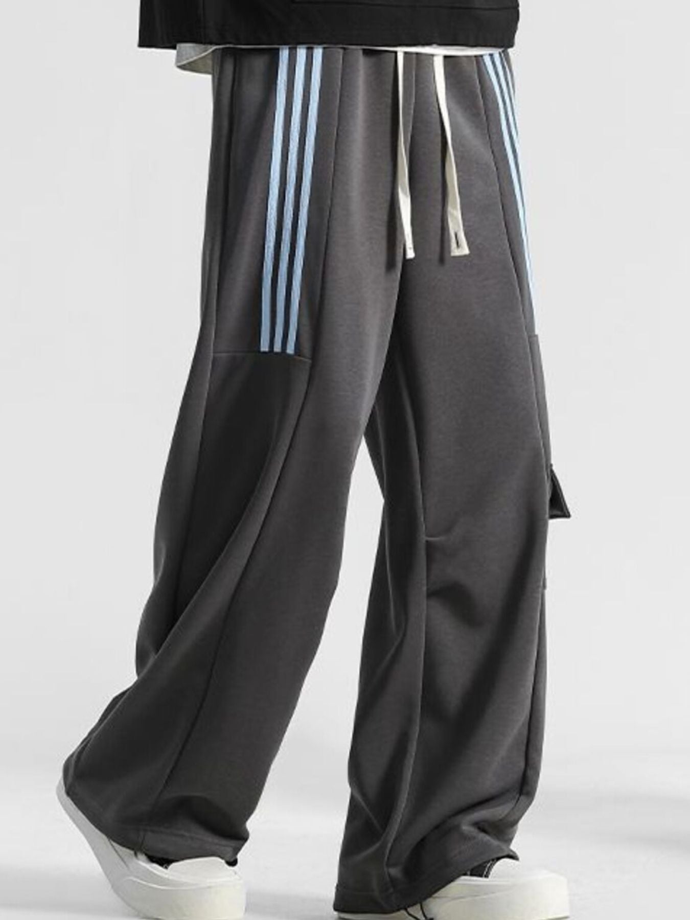 Men's gray loose-fit sweatpants with light blue side stripes and drawstring.