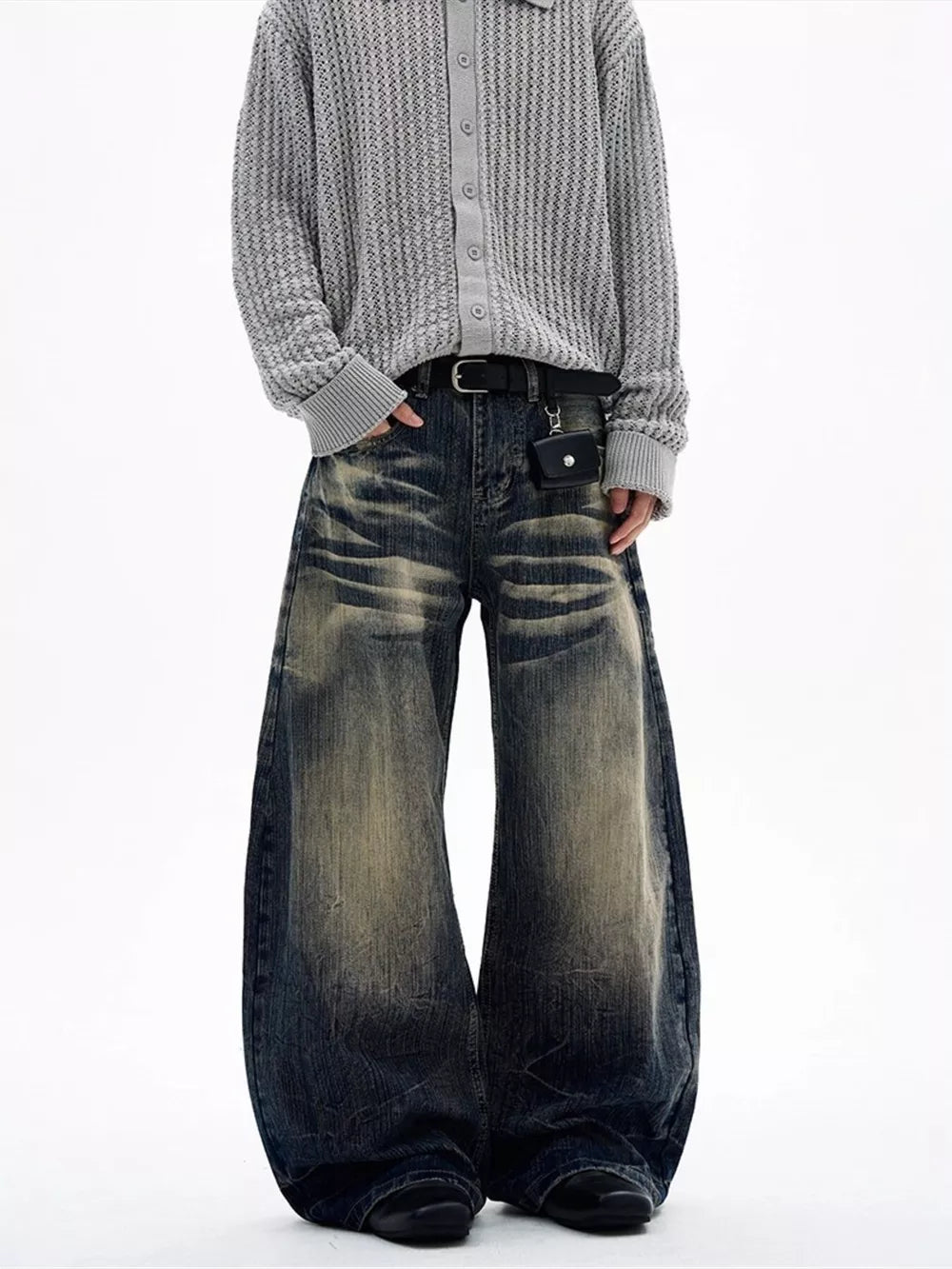 Men's vintage wash wide leg jeans in dark denim with distressed details and a belted waist.