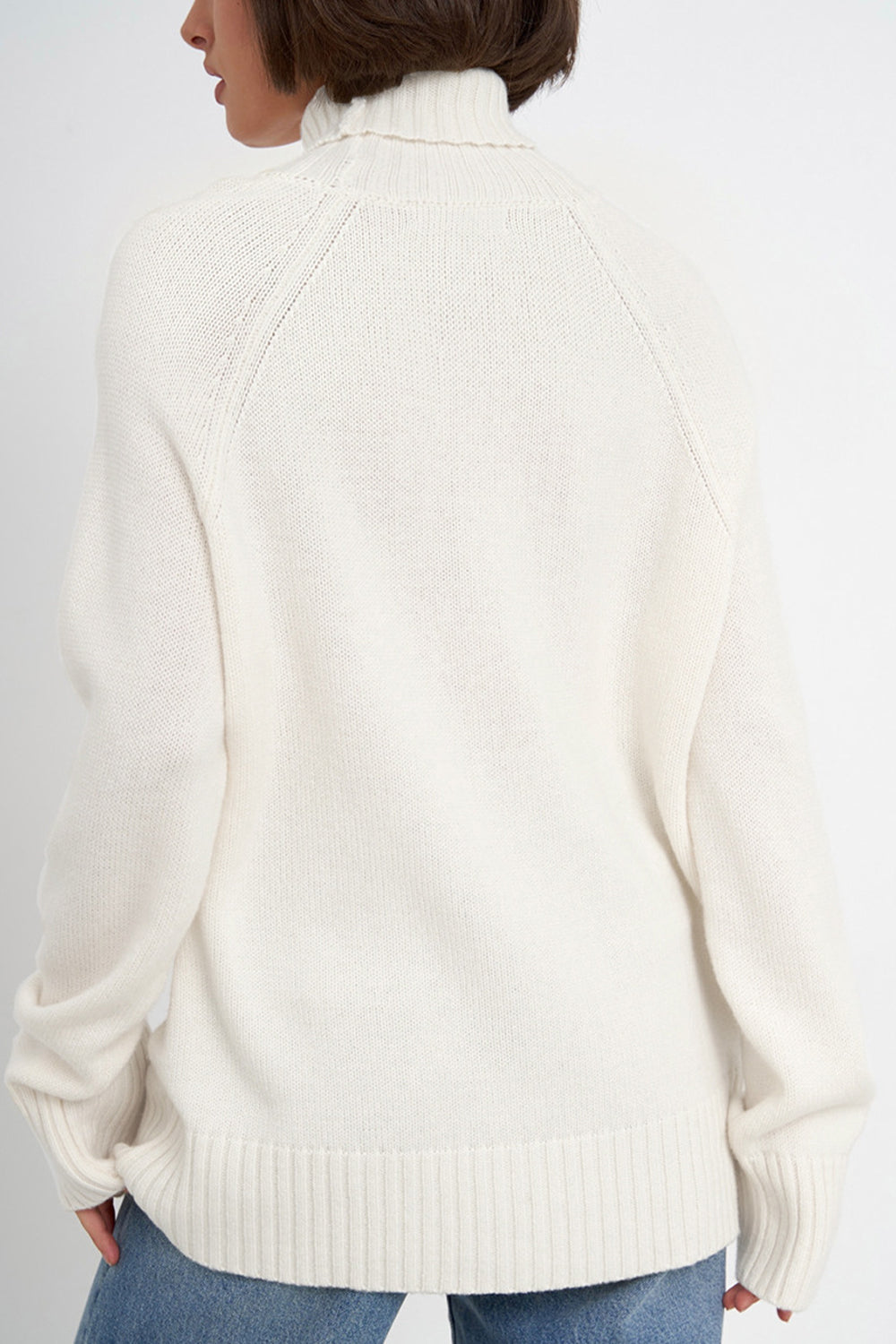 White cashmere turtleneck sweater with raglan sleeves and ribbed cuffs and hem.