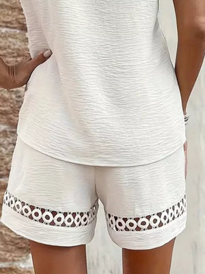 White lace-trimmed shorts with circular cutouts on the hem
