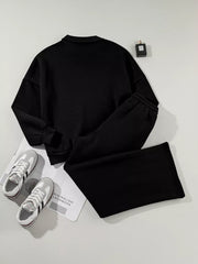 Black zip-up jacket and drawstring pants set, comfortable cotton activewear.