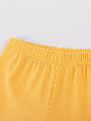 Children's yellow shorts with elastic waistband and drawstring detail.