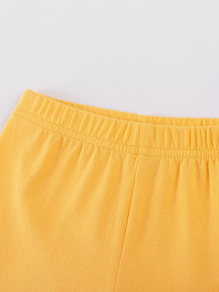 Children's yellow shorts with elastic waistband and drawstring detail.