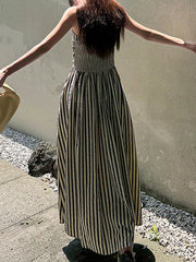 Maxi dress with black and gold stripes, smocked bodice, and a side slit.