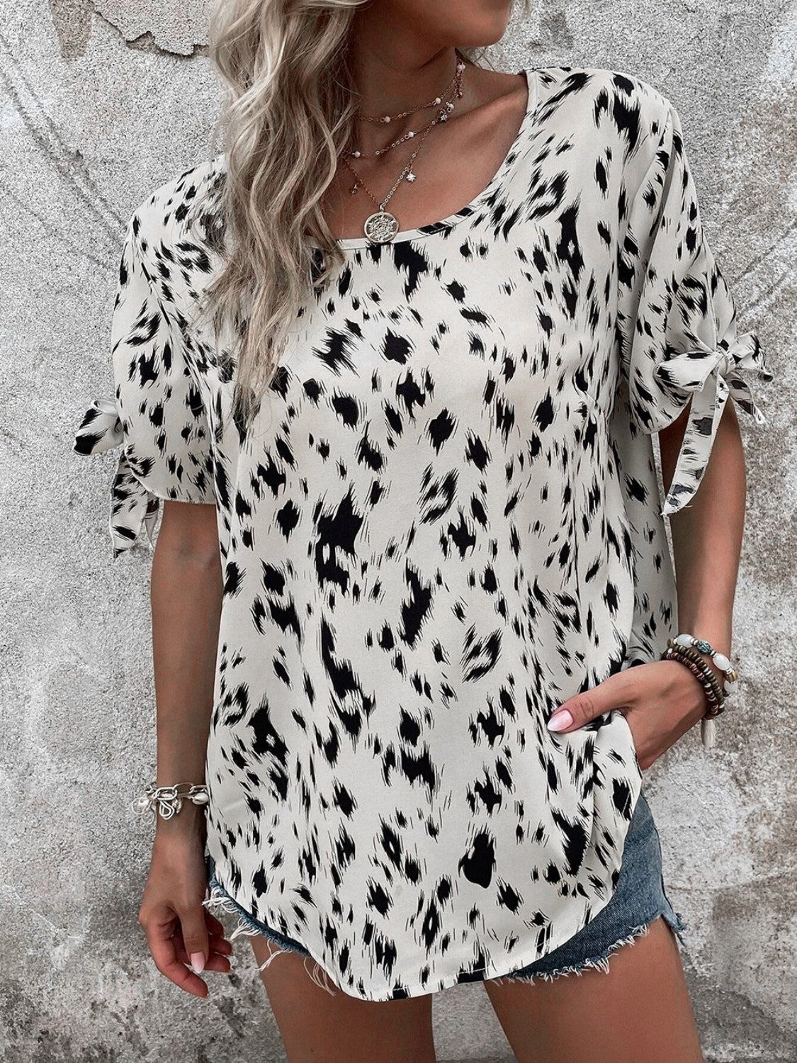 Dalmatian print blouse with bow sleeves and boatneck in cream and black.