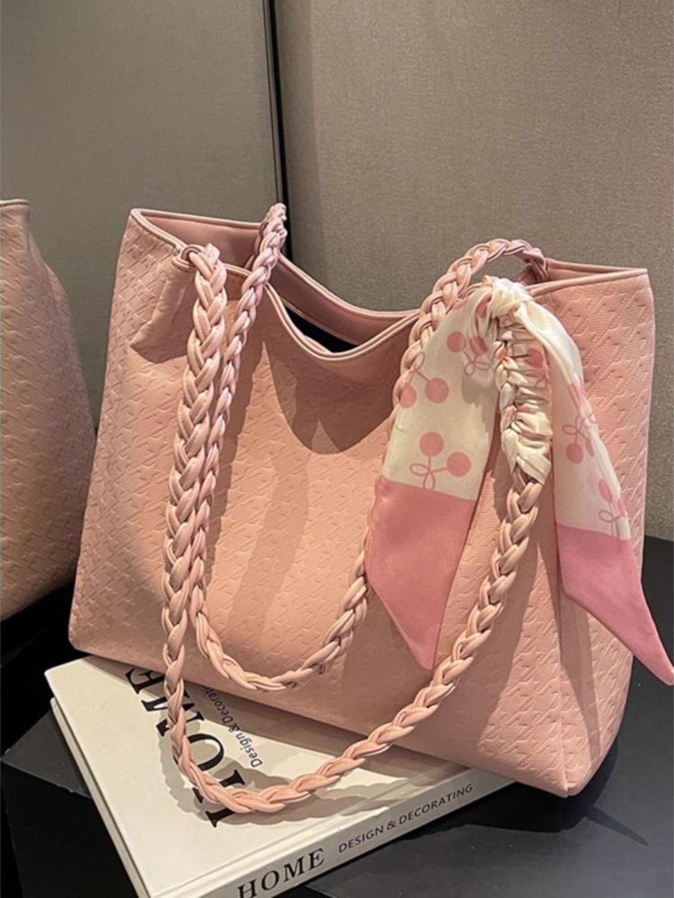 Blush pink shopper bag with braided handles and a cherry print scarf detail.