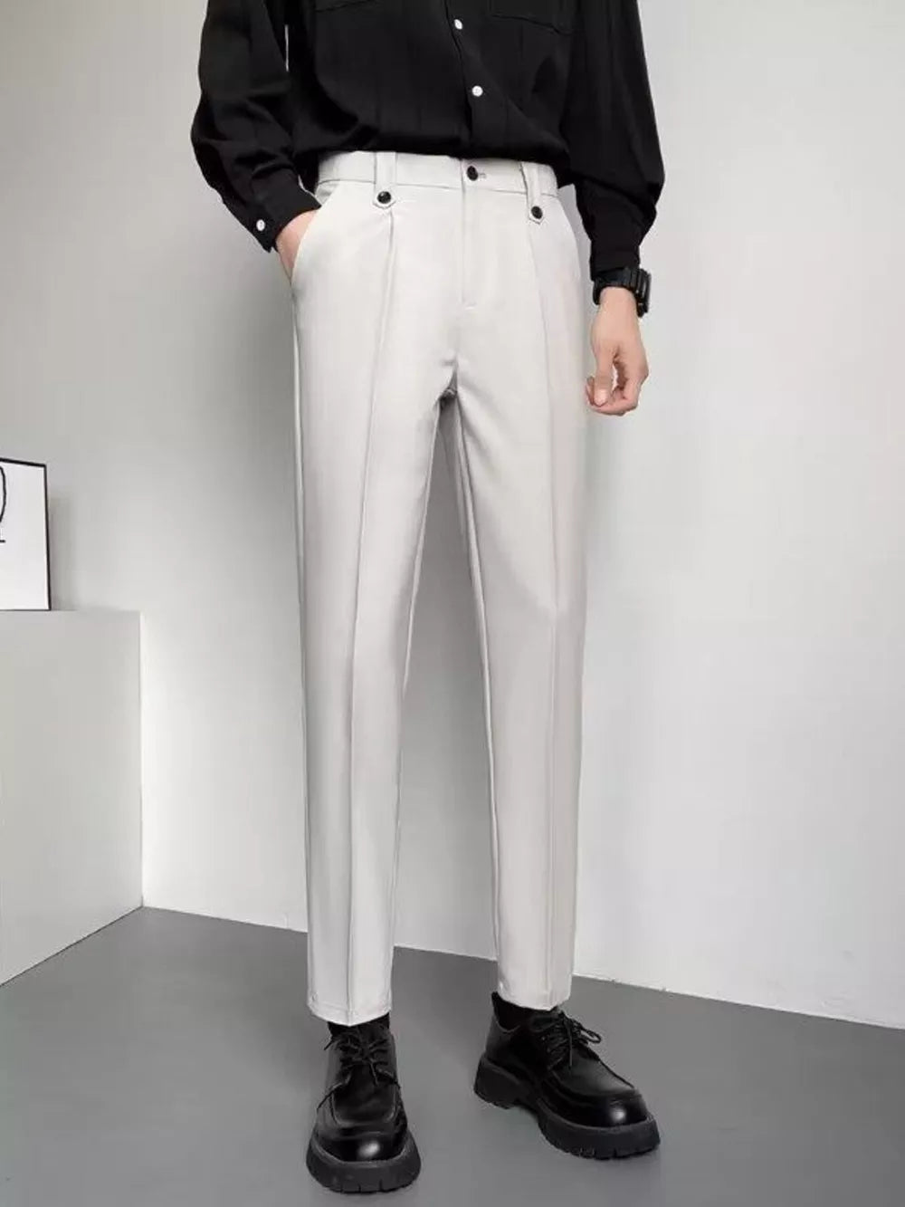 Men's light gray slim fit ankle-length trousers with double button waist detail.