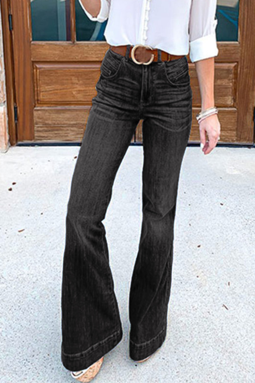 Black denim bell bottom jeans with a high waist and button closure.