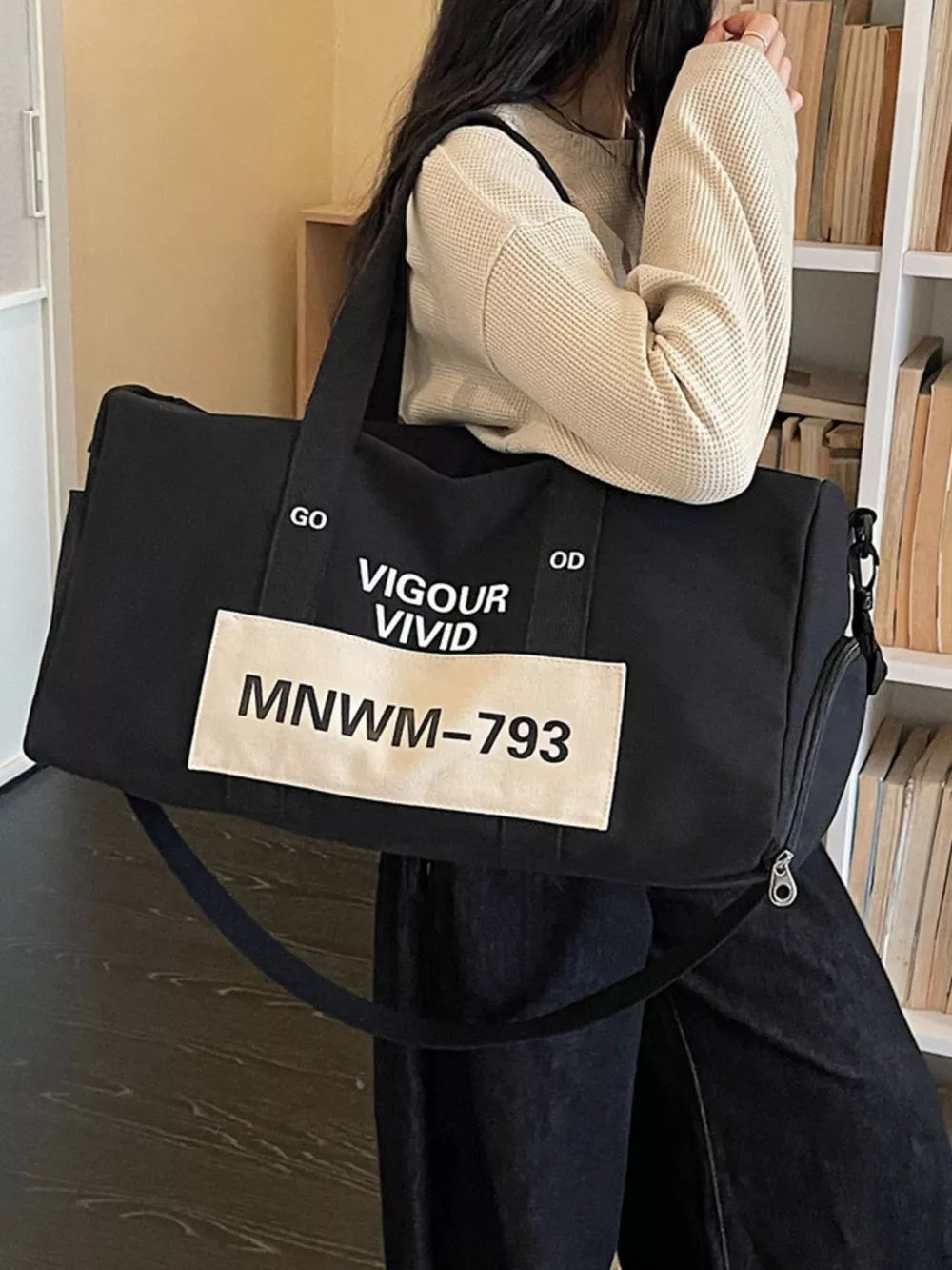 Black nylon travel bag with VIGOUR VIVID and MNWM-793 print details