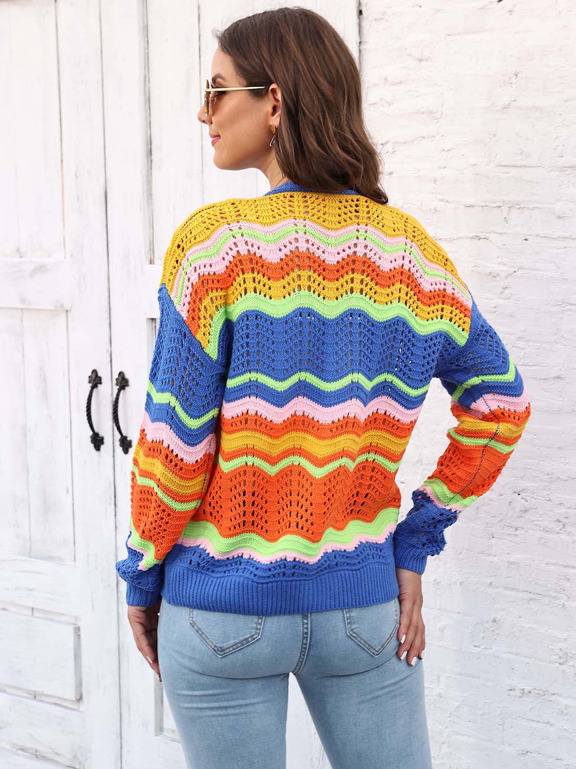 Crochet cardigan with rainbow wave pattern in acrylic, featuring blue, orange, yellow, pink, and green stripes.