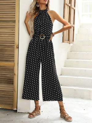 Black polka dot halter romper with wide legs and a belted waist.