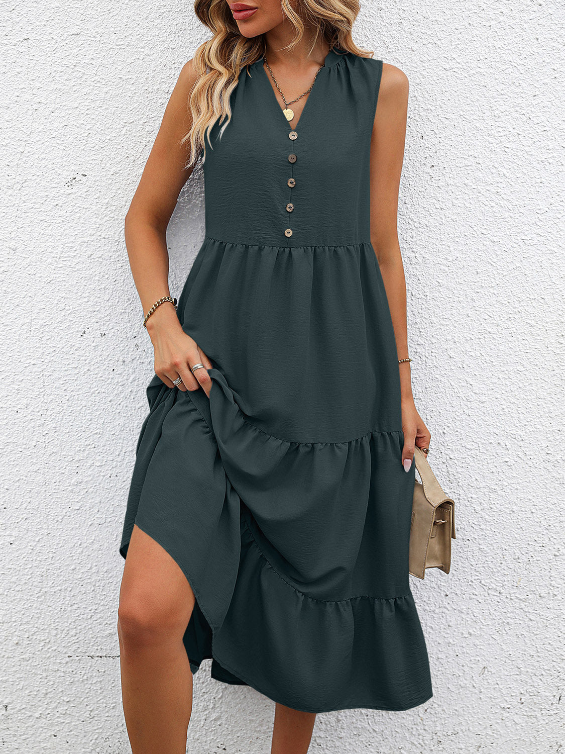 Dark green sleeveless midi dress with V-neck, button front, smocked waist, and tiered skirt.