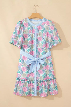 Floral mini dress with contrast trim, button front, puff sleeves, and belted waist.