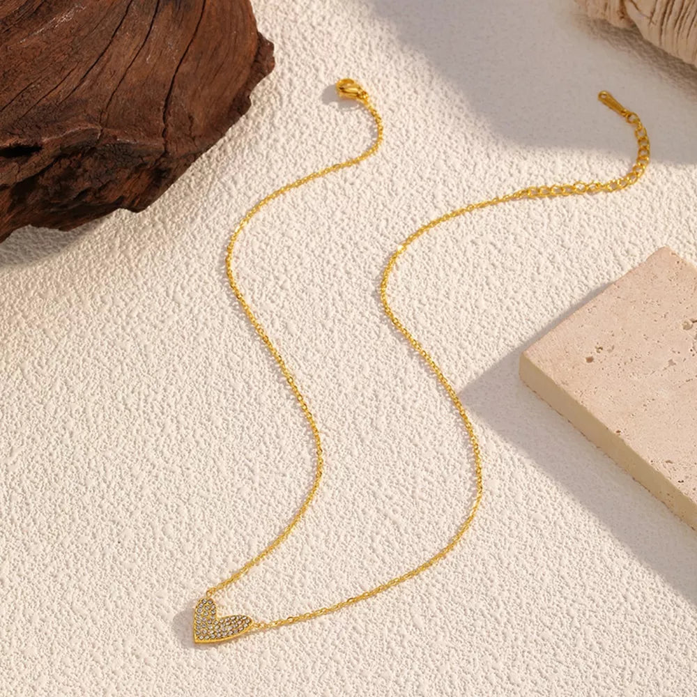 Gold necklace with a delicate rhinestone heart pendant.