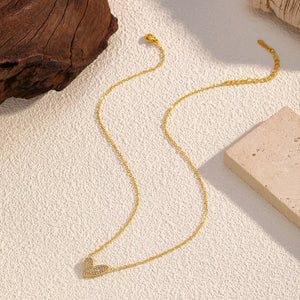 Gold necklace with a delicate rhinestone heart pendant.