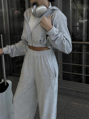 Light gray cropped zip hoodie and wide leg sweatpants set with a white t-shirt.