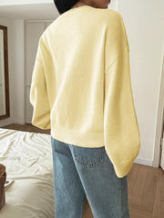 Pastel yellow V-neck knit sweater with ribbed hem and cuffs, acrylic fabric.
