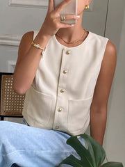 Cream button-down sleeveless vest with crew neck, gold buttons, and pocket details.