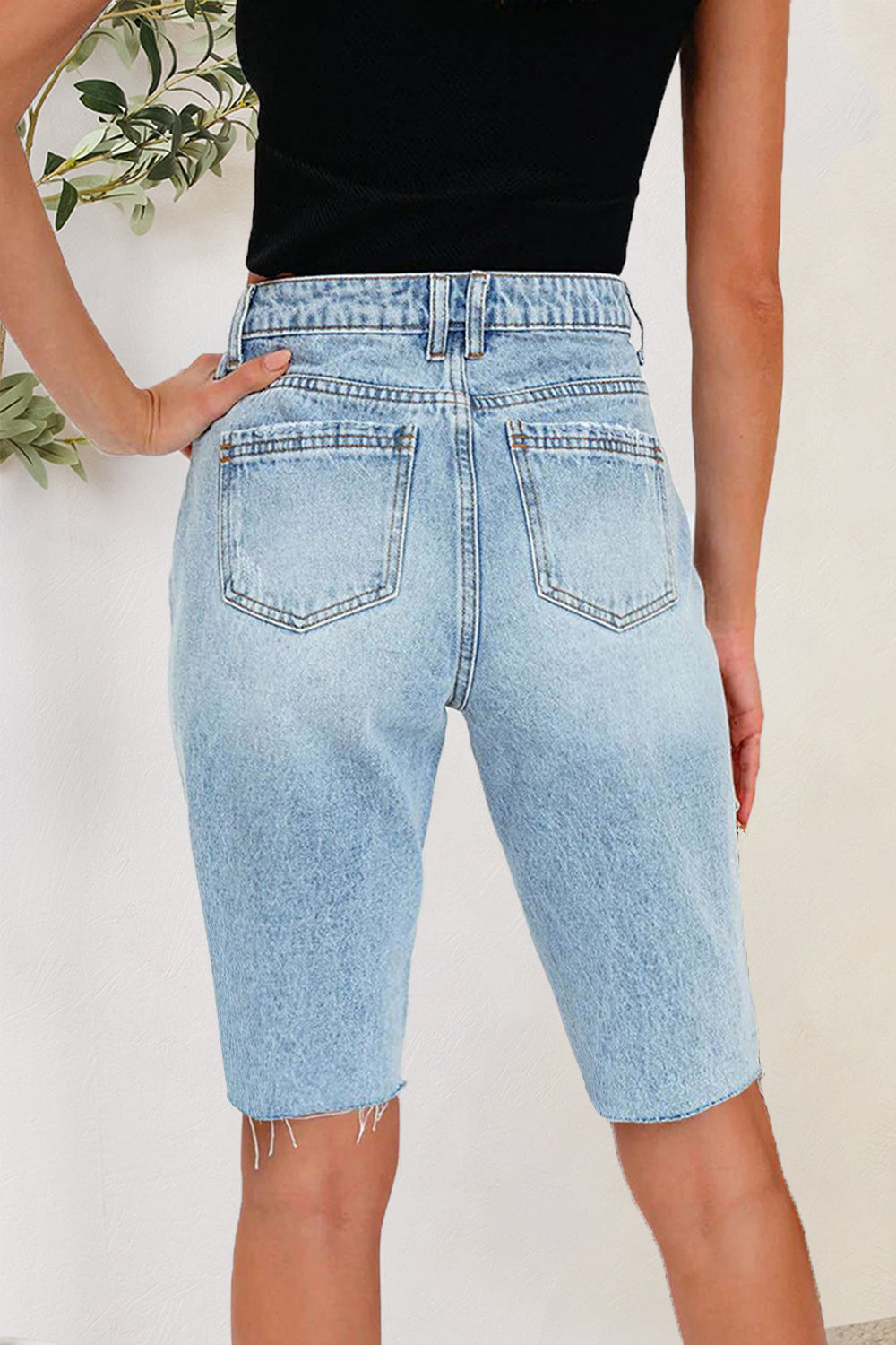 Light wash denim bermuda shorts with distressed hem detail