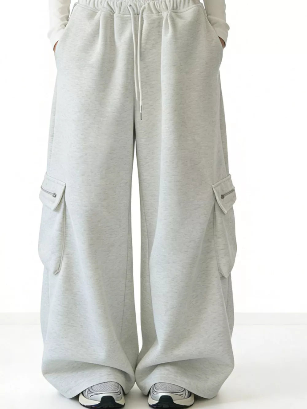 Gray cotton wide-leg cargo sweatpants with drawstring waist and zippered pockets.