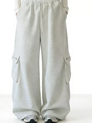 Gray cotton wide-leg cargo sweatpants with drawstring waist and zippered pockets.