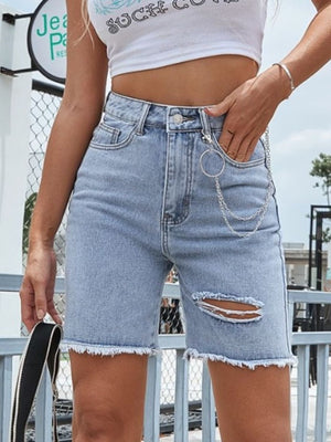 Light wash denim bermuda shorts with distressed details and chain accessory.
