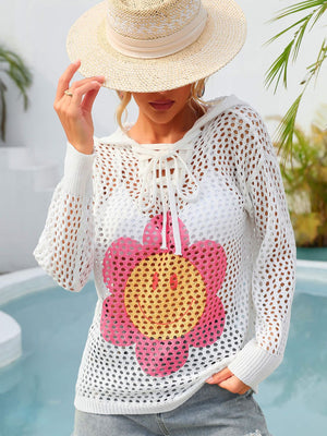 White knit hoodie with lace-up neckline and smiley flower graphic.