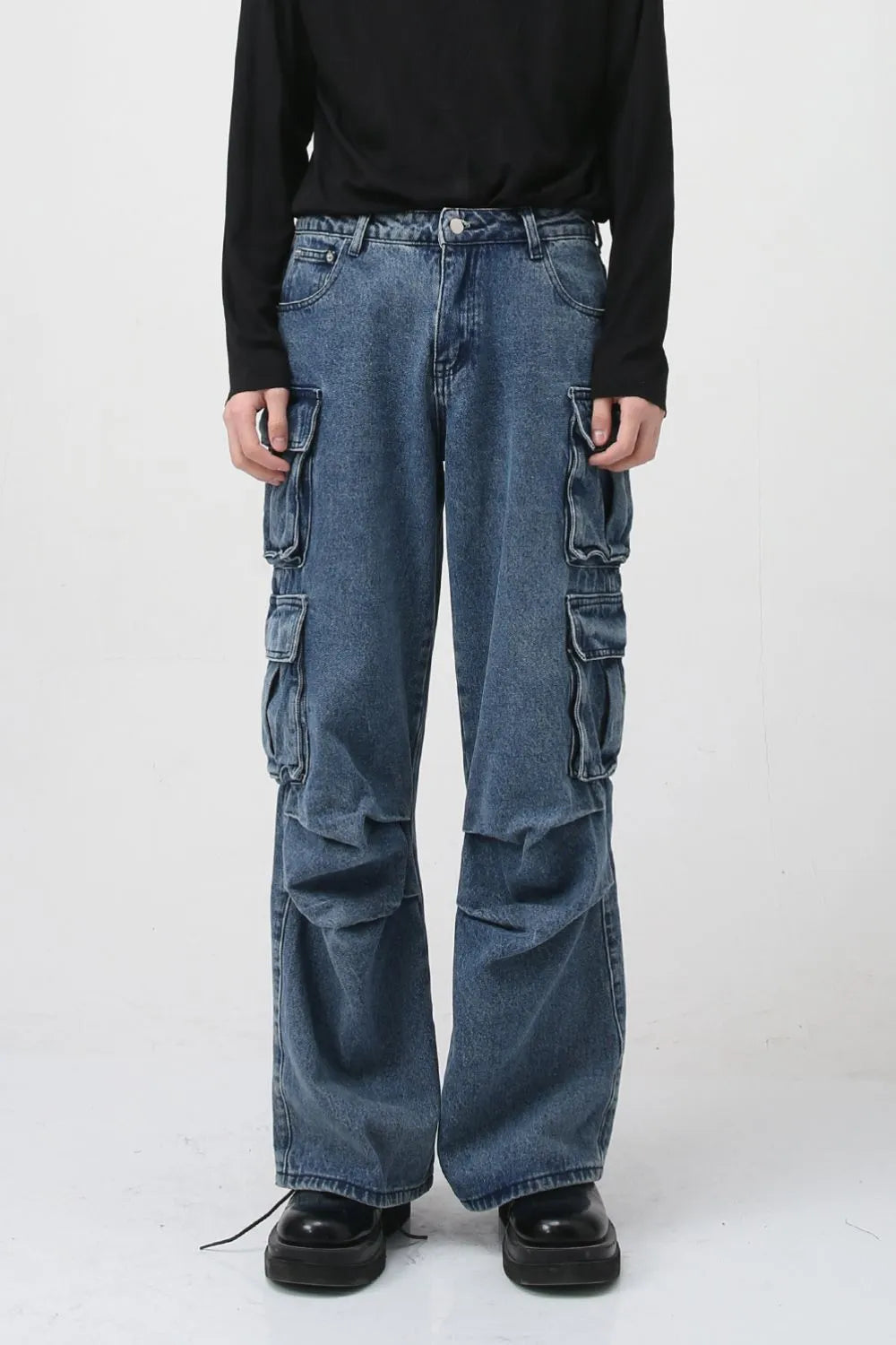 Baggy denim cargo pants in medium wash with multiple utility pockets and a relaxed fit.