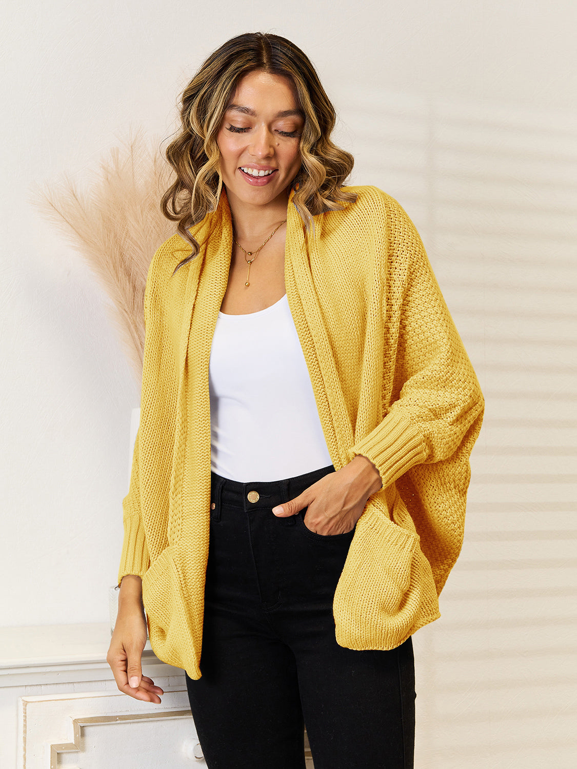 Gold acrylic cocoon knit cardigan with pockets and a relaxed fit.