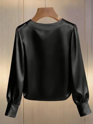 Black satin blouse with round neck, long sleeves, and pearl trim detail.