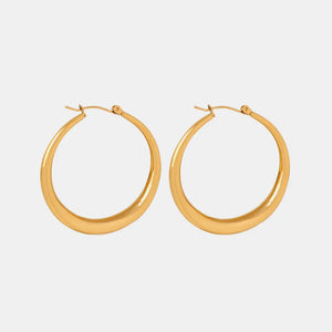 Sculpted oval gold hoop earrings with a polished finish.