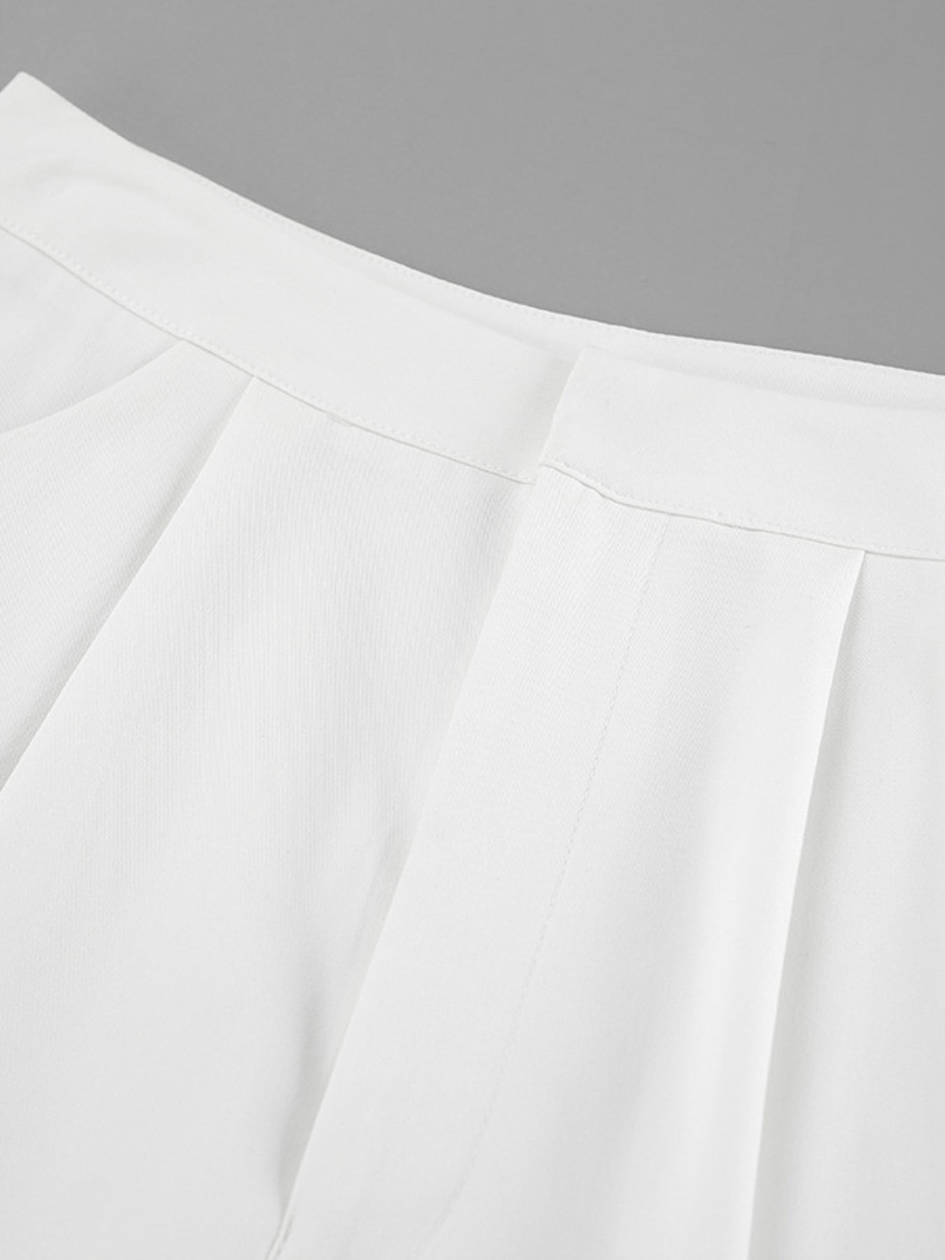 White two-piece set pants detail with pleats and snap closure