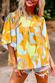 Vibrant abstract print polyester maternity shirt with wide sleeves and a gathered empire waist.
