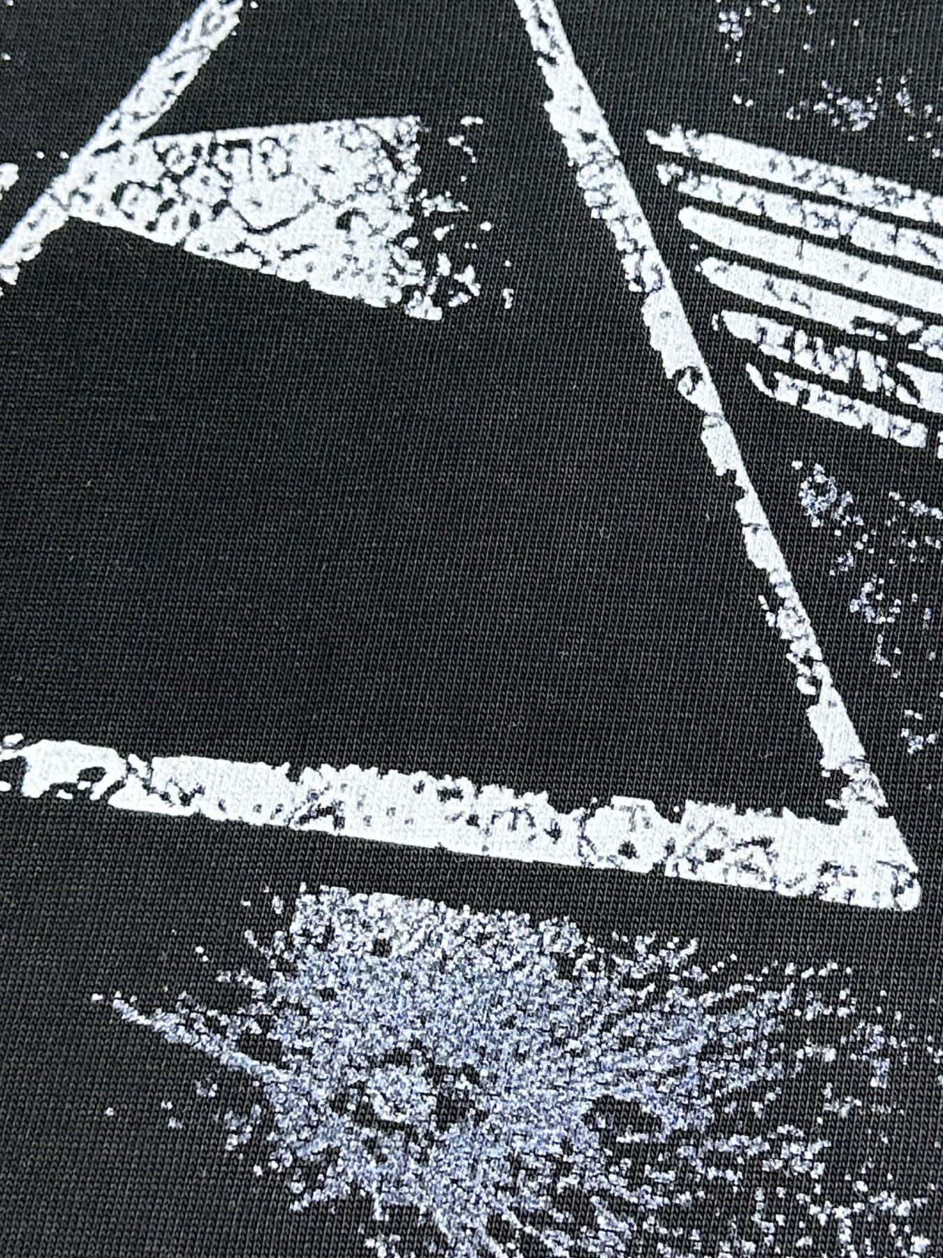 Black cotton blend t-shirt with a distressed white geometric graphic print.