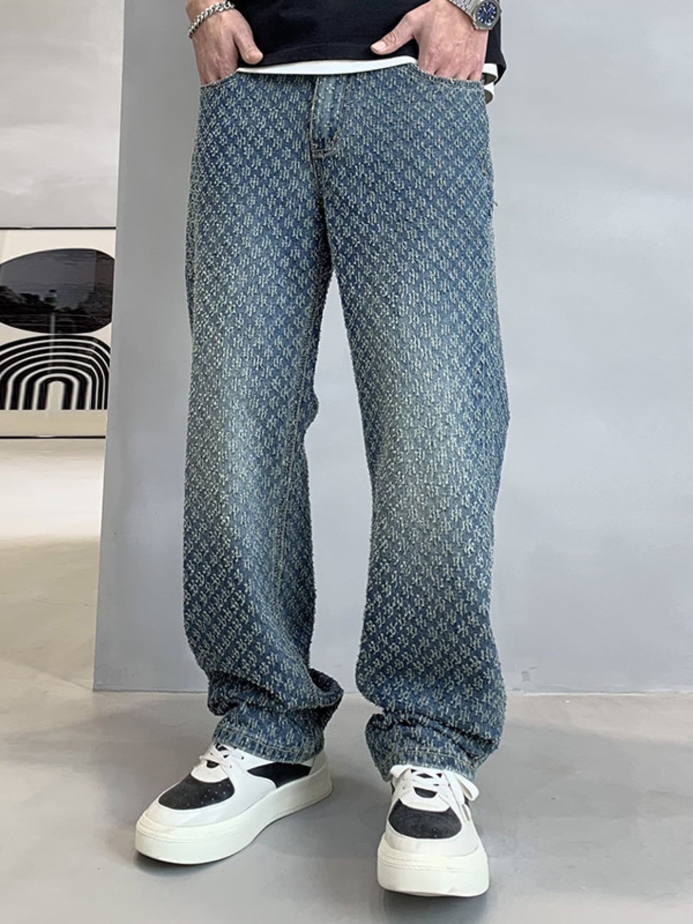 Relaxed fit blue denim jeans with allover textured pattern and faded wash