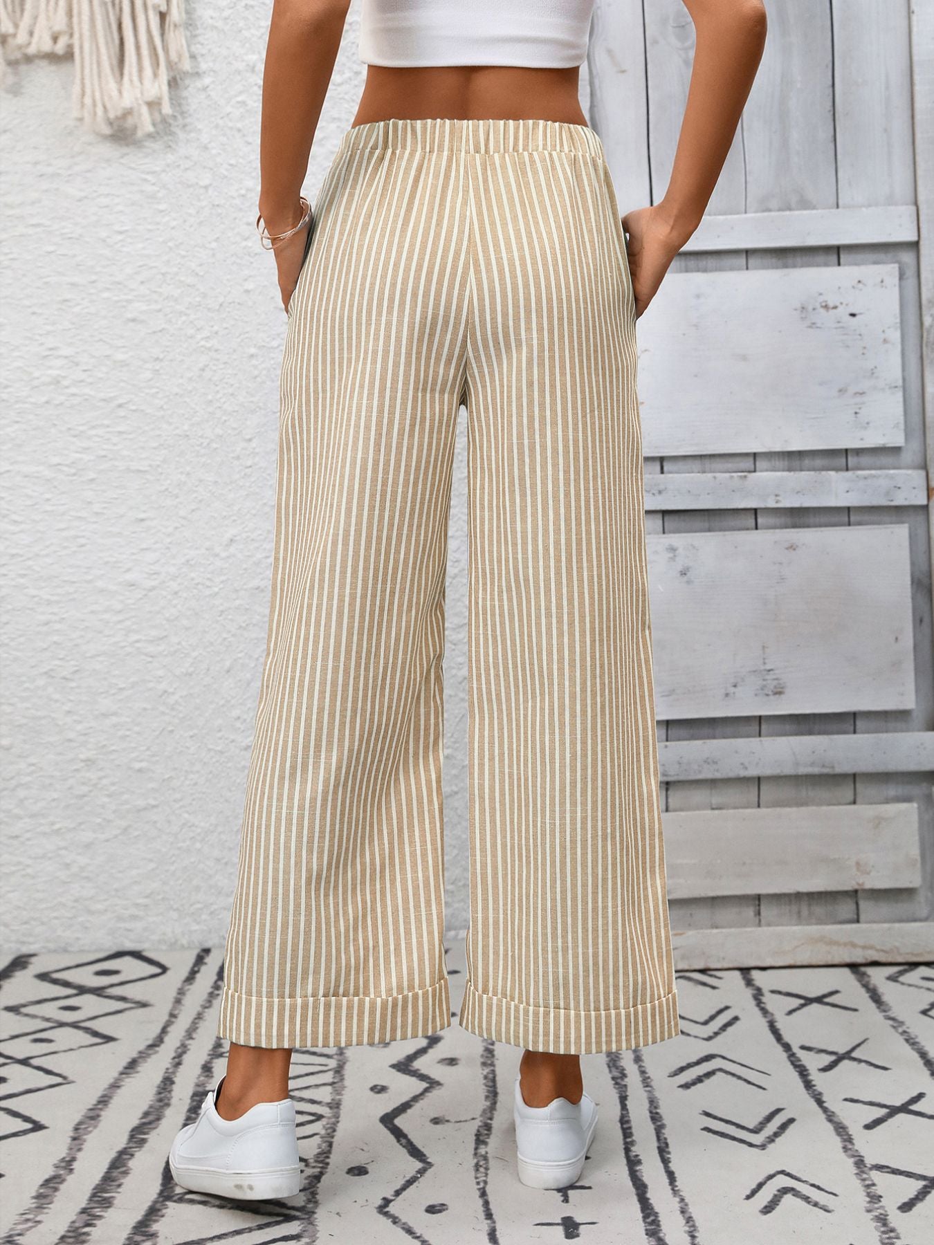 Drawstring wide leg pants in apricot with vertical stripes and pockets.