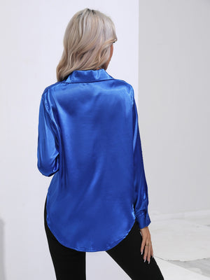 Royal blue satin tie-front blouse with buttoned cuffs and a curved hem.