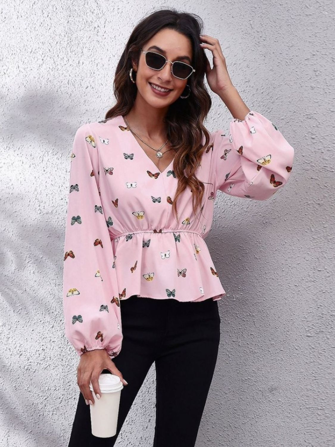 Dusty pink peplum blouse with butterfly print, V-neck, long sleeves, and gathered waist