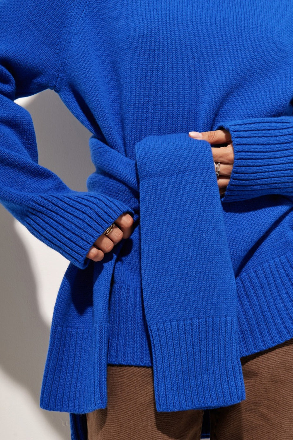 Royal blue cashmere turtleneck sweater with ribbed cuffs and a tie detail.