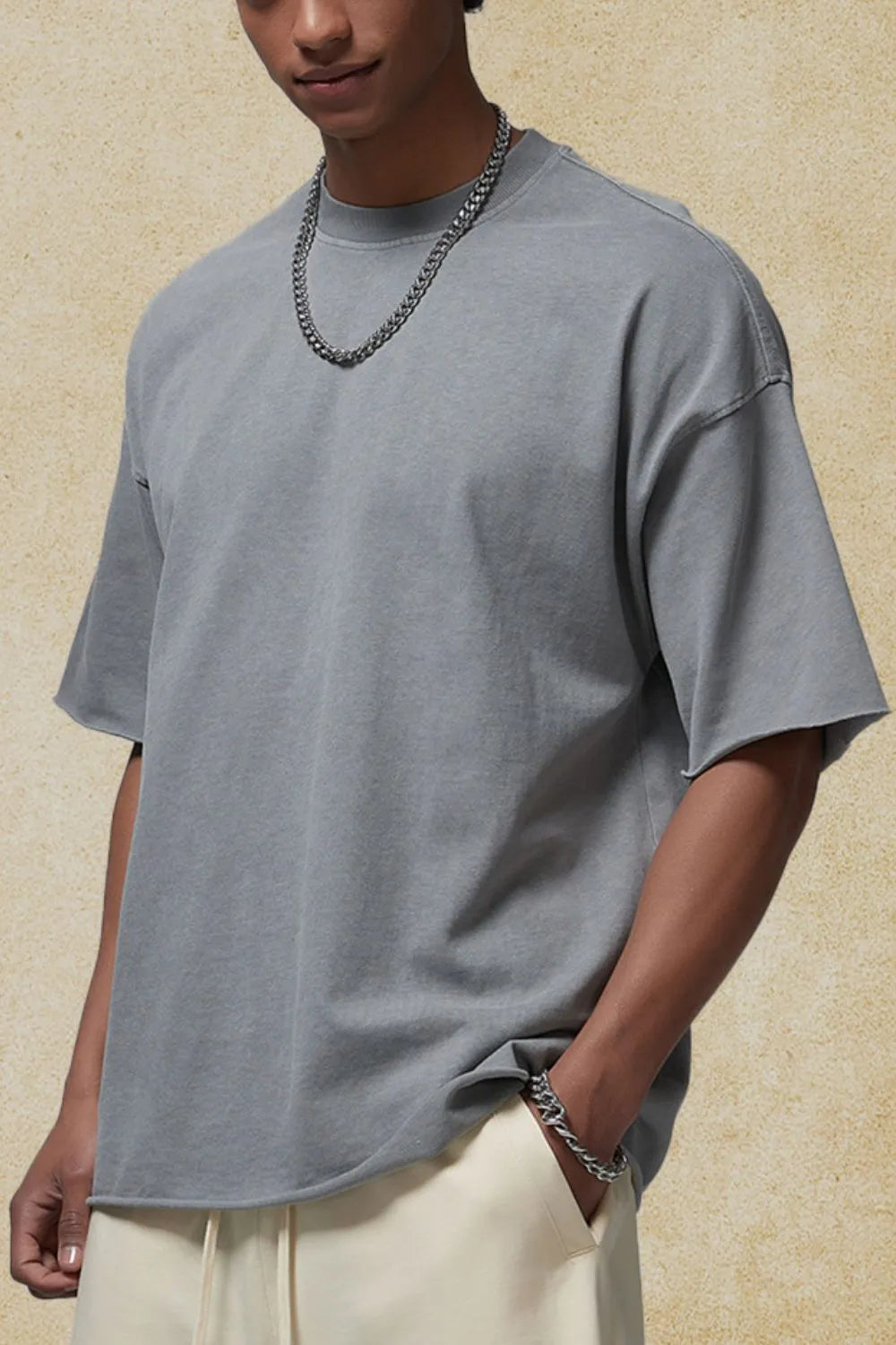Gray boxy tee with raw hem and relaxed fit, crew neck, short sleeves.