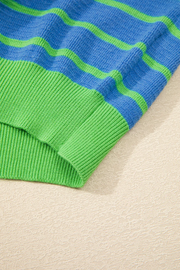 Waffle knit sweater with blue and green stripes and ribbed cuffs.